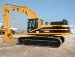 A yellow caterpillar excavator is parked in a dirt lot.