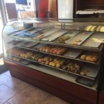A bakery with a display case full of donuts.