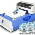 A t - shirt printing machine with a box of t - shirts.