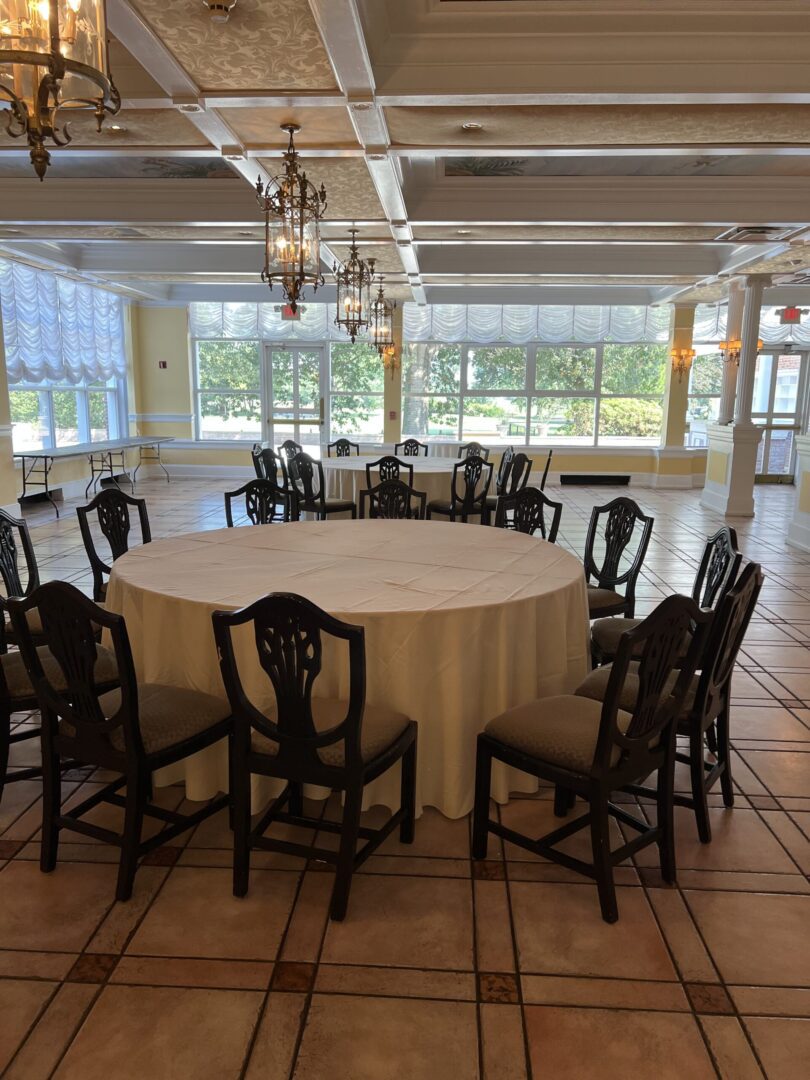 A large room with a round table and chairs.