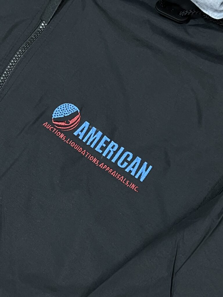 A black jacket with a logo on it.